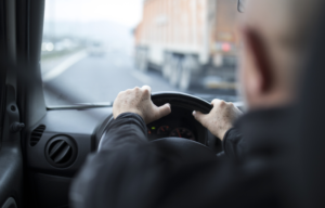 THE VIEW FROM THE CAB OF A TRUCK, WITH A DRIVER'S HEAD IN THE FOREGROUND