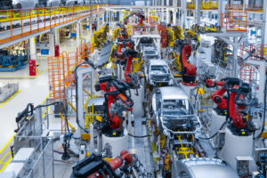 Multiple cars are being put together by robotic arms on an assembly line inside of a factory. Photo: iStock.com/Traimak_Ivan