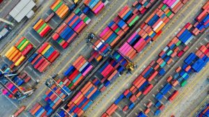 BRIGHTLY COLORED SHIPPING CONTAINERS ON A DOCK, SEEN FROM ABOVE