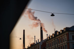 Smoke rises from the chimney of the factory building in the morning light in Munich, Germany. Photo: iStock.com/Wirestock