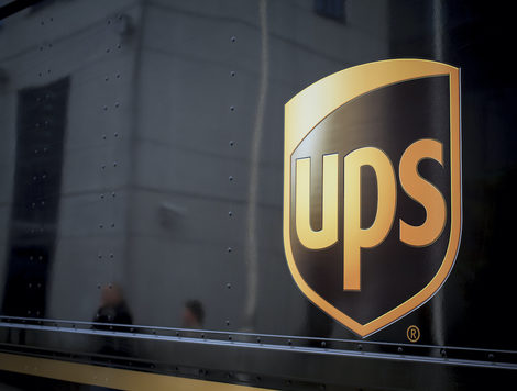 A CLOSE-UP OF THE UPS LOGO CAN BE SEEN ON THE SIDE OF A BROWN VEHICLE