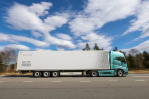 A TRUCK ON THE HIGHWAY SPORTS "ELECTRIC POWERED" LETTERING ON THE SIDE